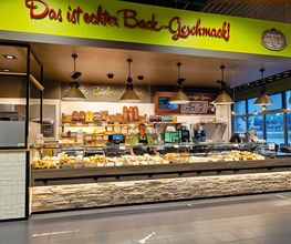 Bäckerei und Bake-off-Shop
Echte Heide-Bäcker backen echt lecker! Kross splittern die Brötchen der Bäckerei Meyer im Vorkassenbereich. Beim Anblick der Brote mit goldbrauner Kruste läuft uns das Wasser im Mund zusammen. Freuen Sie sich auf herzhaftes Brot aus natürlichem Sauerteig und süßes Feingebäck. Baguettes, belegte Brötchen, Brezeln, Snacks oder Torten und Kuchen – lecker!