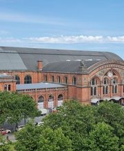 Blick aus dem Fenster auf das Bahnhofsgelände mit einem schönen, großen Gebäude.