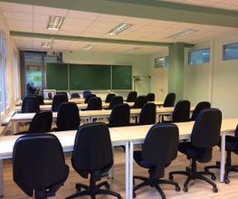 Klassenraum der WBS SCHULEN Dresden mit Tischen und Stühlen.