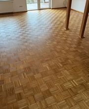 Das Bild zeigt ein aufgearbeitetes Eichen-Mosaikparkett mit geölter Oberfläche. Nach dem Schleifen kommt die natürliche Struktur des Holzes klar zur Geltung, das Öl verleiht dem Boden einen warmen, matten Farbton.