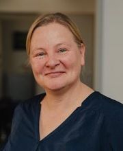 Eine Frau mit blauem Oberteil.