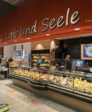 Frischetheke
Ein Highlight ist unser Dry-Aged Reifeschrank. Hier lagern wir qualitativ hochwertige Fleischwaren, die durch den Wasserentzug besonders geschmackvoll werden. Darunter sind zum Beispiel Entrecote und Rostbeef. Aber auch unsere anderen Waren sind alle auf ihre Qualität geprüft. Unser geschultes Personal bedient dich gerne mit Fleisch, Wurst, Fisch, Käse und Geflügel. Einige der Fischprodukte werden auch direkt bei uns im Markt geräuchert. Daneben stellen wir auch täglich frische Cremes und Salate für dich her. Weitere Besonderheiten sind das Warfelder Kräuterschwein und Mais Hähnchen. Fragen zur Herkunft und zu Inhaltsstoffen beantworten wir dir selbstverständlich sehr gerne.