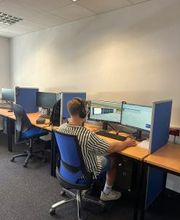 Ein Teilnehmer sitzt an seinem Arbeitsbereich, trägt sein Headset und lernt.