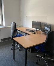 Ein Arbeitsplatz mit Eckschreibtisch, zwei Monitoren und Maus und Tastatur.