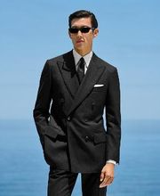 This black striped suit is cut to a tailored fit, offering a refined silhouette with structured shoulders. Paired with slim trousers featuring side-adjusters and a flat front for modern sophistication.