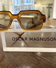 Designerbrille von Oscar Magnuson bei Newels Eyewear in Münster. Die markante Fassung in einem warmen transparenten Farbton zeigt die außergewöhnliche Formensprache moderner Eyewear und ergänzt die Auswahl individueller Designerbrillen im Geschäft.