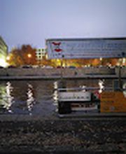 FLAGSHIP.BERLIN auf der Spree vor dem beleuchteten Berliner Regierungsviertel.