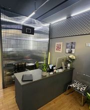 OMEN Lab F-Hain Rezeption mit grauem Tresen und minimalistischem, industriellen Design und modernen Akzenten.