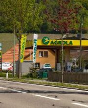 AGROLA Tankstelle in Unterstammheim; im Vordergrund Strasse. Bei Tankstelle Fahne von Landi und Fahne von AGROLA. Totem an Strasse.