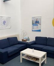 Pausenraum mit zwei Sofas und einem Beistelltisch. An der Wand ein Kalender und ein Plakat.