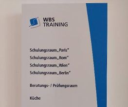 Plakat mit Auflistung der Räume (Schulungsraum Paris, ...)