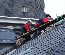 Das Dach einer denkmalgeschützten Kirche in Leverkusen wird mit Schiefer in altdeutscher Deckung neu eingedeckt.