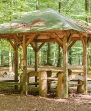 Eine überdachte Sitzgruppe im FriedWald Kisdorf lädt zum Verweilen ein.