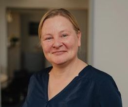 Eine Frau mit blauem Oberteil.