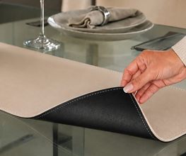 Individuelle Wende-Tischläufer aus hochwertigem Kunstleder, nach Maß gefertigt. Zwei Seiten in frei wählbaren Farben, pflegeleicht und abwischbar. Mit Ziernaht und sauber umlaufend kaschiertem Rand – für Wohnen, Gastronomie und Hotellerie.