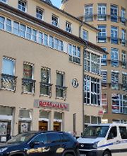 Außenansicht eines Gebäudes mit einer Rossmann.Filiale im Erdgeschoss.