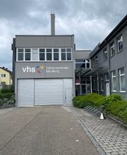 Außenansicht von dem Gebäuder der Volkshochschule Mainburg mit Aufschrift auf der grauen Fassade.