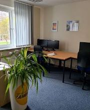 PC-Arbeitsplätze mit Monitoren, Tastaturen, Maus und Headsets.