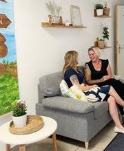 Auf der Couch sitzen Teilnehmerinnen die sich fröhlich unterhalten.