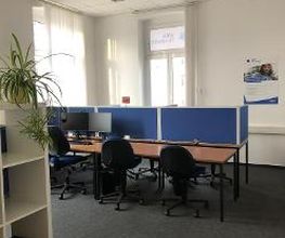 Schulungsraum mit mehreren Arbeitsplätzen mit jeweils 2 Bildschirmen, einem Bürostuhl und Tastatur und Maus.