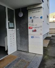 Haupteingang mit Beschilderung der Stockwerke.