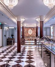 LA BOUTIQUE POUR DÉCOUVRIR TOUTE L’OFFRE SUCRÉE

Dans un décor bleu avec lustre et mur floral, les vitrines en laiton doré présentent comme de précieux bijoux, les macarons, les chocolats, les Eugénie et les pâtisseries du jour.