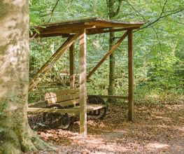 Eine überdachte Bank im FriedWald Ostheide lädt zum Verweilen ein.