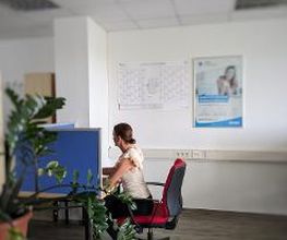 Teilnehmerin Sitzt am Arbeitsplatz mit PC Ausstattung