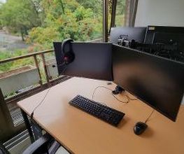 Schreibtisch im Trainingsraum mit zwei Bildschirmen, Tastatur, Maus und Headset.