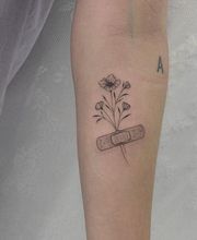 minimalistisches Fineline Blumen Tattoo mit einem Pflaster. sehr softes Shading, angebracht auf dem Unterarm.