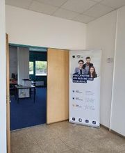 Eingang zum Schulungsraum. Geöffnete Türe. Davor steht ein Werbeaufsteller von WBS TRAINING.