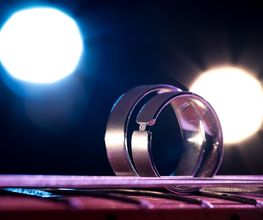 Hochzeitsfotograf Tom Maiwald - Kreative Detailaufnahme von Eheringen mit farbigem Licht und unscharfen Lichtquellen im Hintergrund. Hochzeitsfotografie mit Fokus auf persönliche Details des Hochzeitstags.