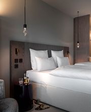 Vibrant Living in modernem Ambiente. Unsere lichtdurchfluteten Zimmer bieten ein unbeschwertes Flair statt steifem Luxus. Mit stetem Blick auf den See und einem durchdachten Spiel mit den Elementen schaffen wir einen Rückzugsort, der Ruhe und Leichtigkeit vermittelt.
