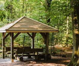 Eine überdachte Sitzgruppe im FriedWald Buxtehude bietet Besuchern Schutz.