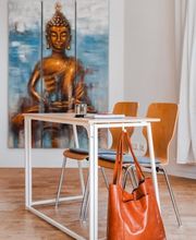 Webstudio Dresden Stilvoll eingerichteter Raum mit Buddha-Kunstwerk, Tisch und Stühlen, inspirierende Atmosphäre für Gespräche.