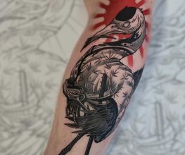Asiatisches Tattoo Motiv, ein Samurai Kranich mit einer roten Sonne als Hintergrund beim Kopf. Der rest ist Blackwork tätowiert.