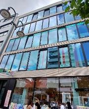 Gebäudeansicht mit Fensterfront und Drogeriemarkt im Erdgeschoss