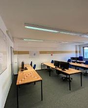 Ein Arbeitsbereich mit mehreren Tischen, auf denen sich Monitore und Computer befinden.