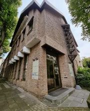 Außenansicht des Schulungsgebäudes. Das Gebäude ist von einer grünen Landschaft umgeben. 