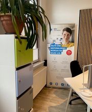 Co-Working-Raum mit Regalen und Tisch.