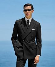 This black striped suit is cut to a tailored fit, offering a refined silhouette with structured shoulders. Paired with slim trousers featuring side-adjusters and a flat front for modern sophistication.