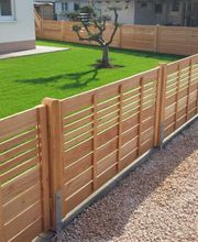 Ein moderner Garten: SaubereRandsteine, stilvolles Kiesbeet, frisch verlegter Rollrasen, ein Olivenbaum als Highlight und ein passender Holzzaun als Abschluss.