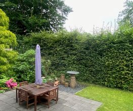 Garten mit Gartentisch und Stühlen.