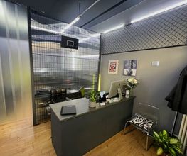 OMEN Lab F-Hain Rezeption mit grauem Tresen und minimalistischem, industriellen Design und modernen Akzenten.