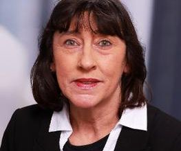 Eine Frau mit dunklen Haaren und schwarzem Blazer.