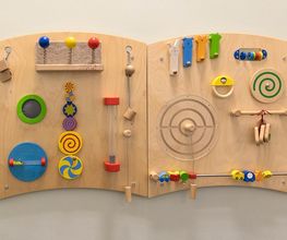 Holzwandpanel in der Kita mit vielfältigen motorischen und sensorischen Spielelementen