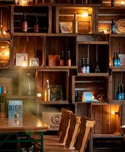 Der gemütliche Ausschankraum der Wildwuchs Brauerei in Hamburg überzeugt mit rustikalem Charme und liebevollen Details. Warme Lichtquellen, alte Holzkisten und handgebraute Biere schaffen eine authentische Atmosphäre, die zum Verweilen einlädt.