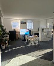 Aufenthaltsbereich mit Tisch, Stühlen, Screen und Pflanzen