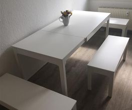 Aufenthaltsbereich mit weißem Tisch und Sitzbänken