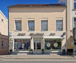 Außenansicht des BRILLENHAUS Optik & Akustik in Grimmen mit Schaufenster und Eingangsbereich.